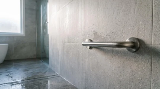 Barre d'appui inox fixée solidement au mur d'une douche moderne et épurée
